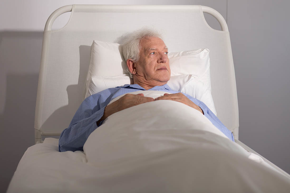 Anziano malato di tumore nel letto