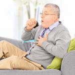 Anziano sul Divano con Tosse e Malattie Respiratorie