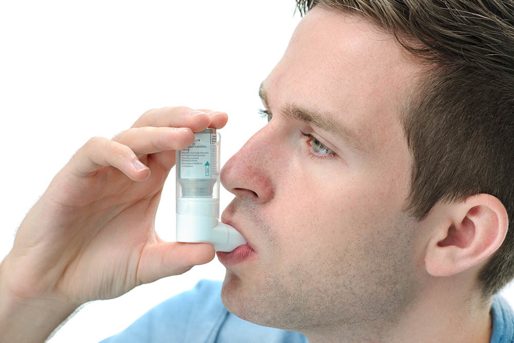 Uomo con asma e inalatore