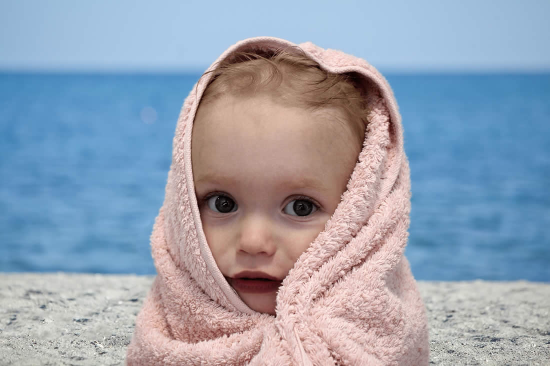 Bimbo al mare durante bagno labra unghie orecchie viola